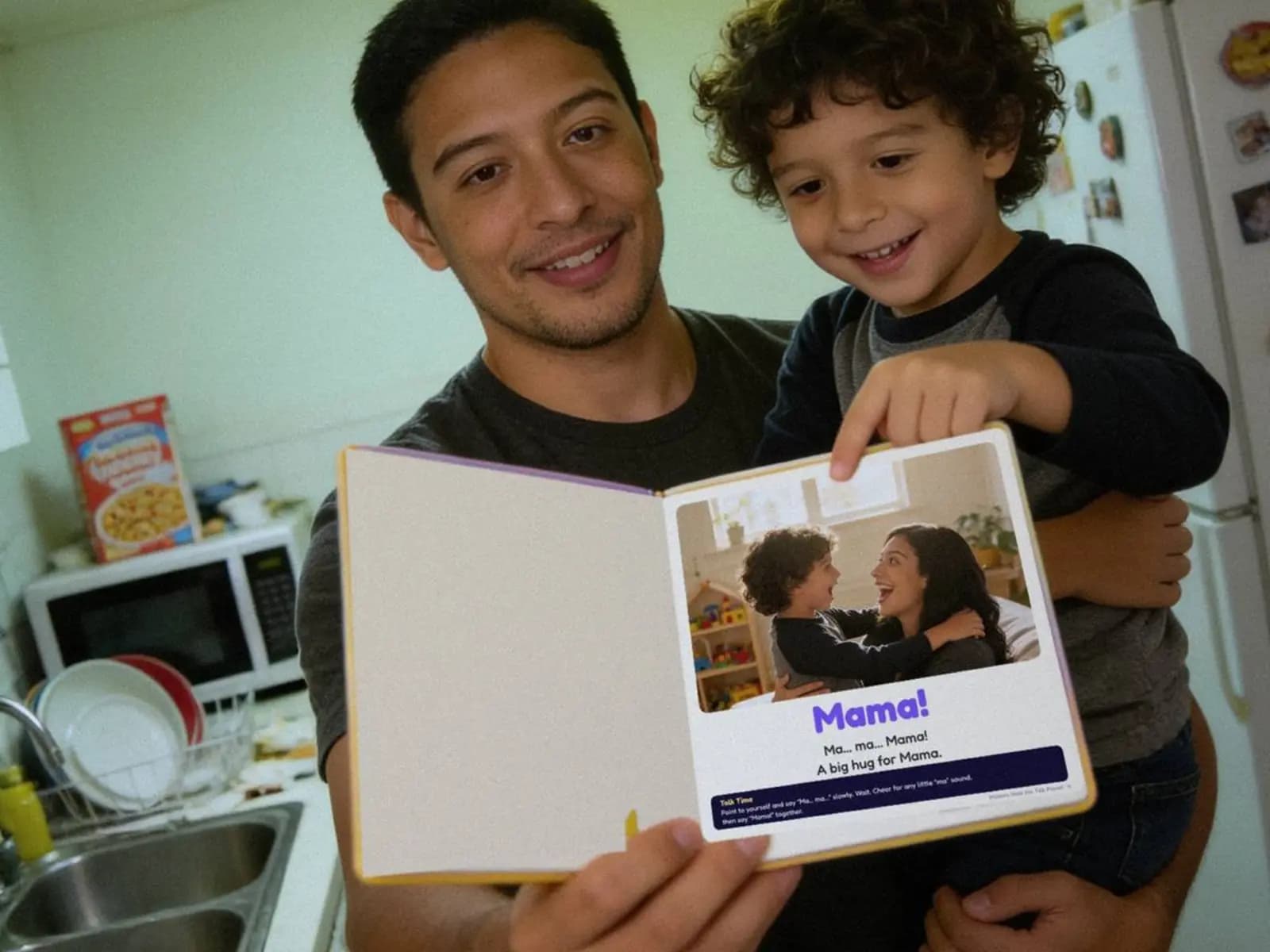 Illustration of a father in the kitchen holding his son on his hip, the hardcover open at the 'Mama!' page.